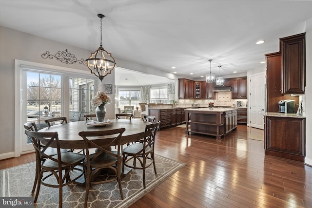 dining area featuring an inviting chandelier and dark wood-type flooring