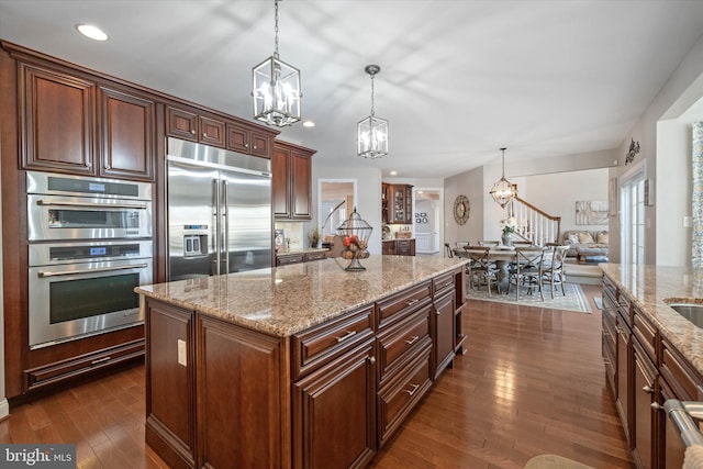 kitchen featuring hanging light fixtures, a notable chandelier, stainless steel appliances, and a kitchen island