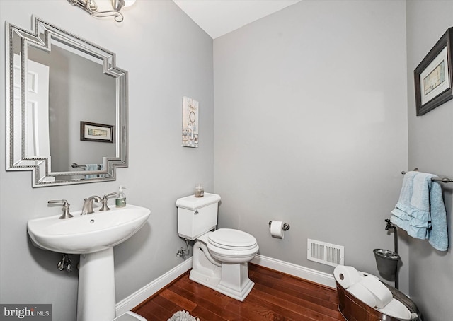 bathroom with hardwood / wood-style flooring, toilet, and sink