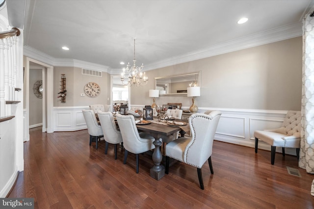 dining room with crown molding, dark hardwood / wood-style floors, and an inviting chandelier