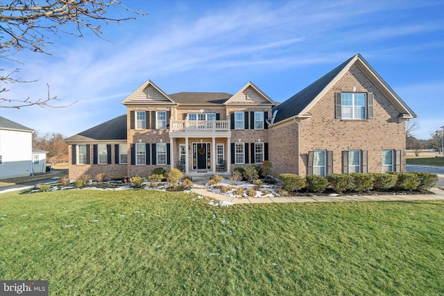 view of front of house featuring a balcony and a front lawn