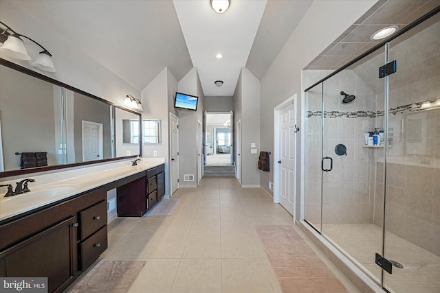 bathroom with tile patterned flooring, vanity, lofted ceiling, and walk in shower