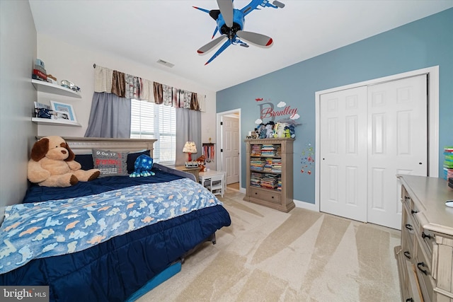 bedroom with ceiling fan, a closet, and light carpet