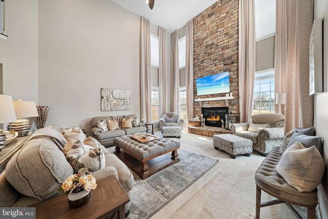 living room with a large fireplace, carpet floors, and a high ceiling