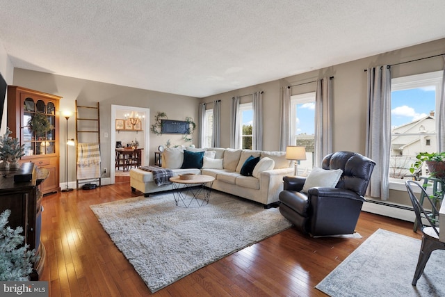 living room featuring wood-type flooring, a baseboard radiator, a chandelier, and a textured ceiling