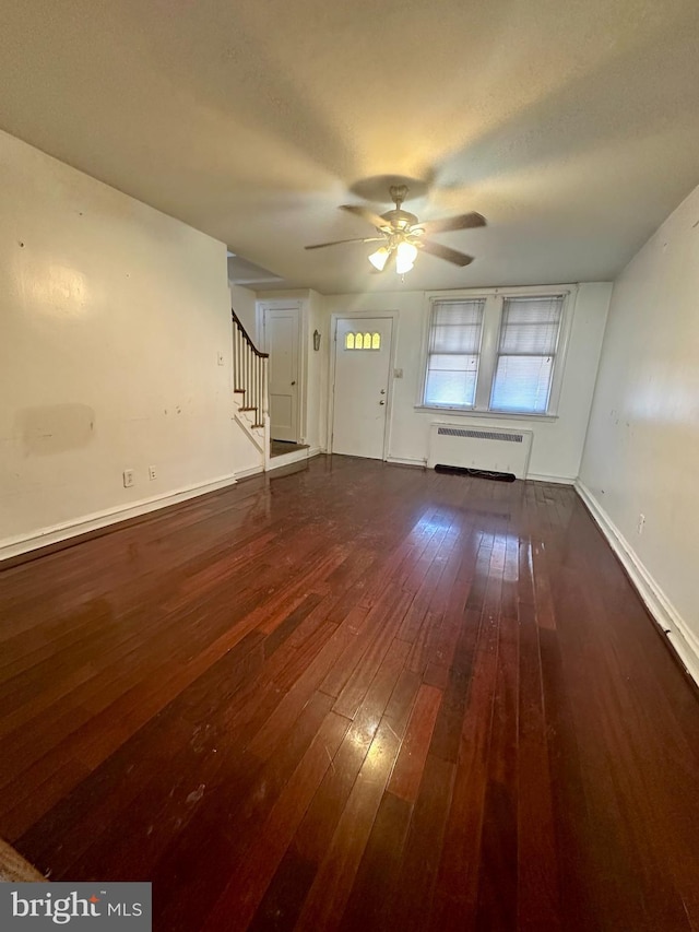 unfurnished living room featuring radiator heating unit, a textured ceiling, dark wood-type flooring, and ceiling fan