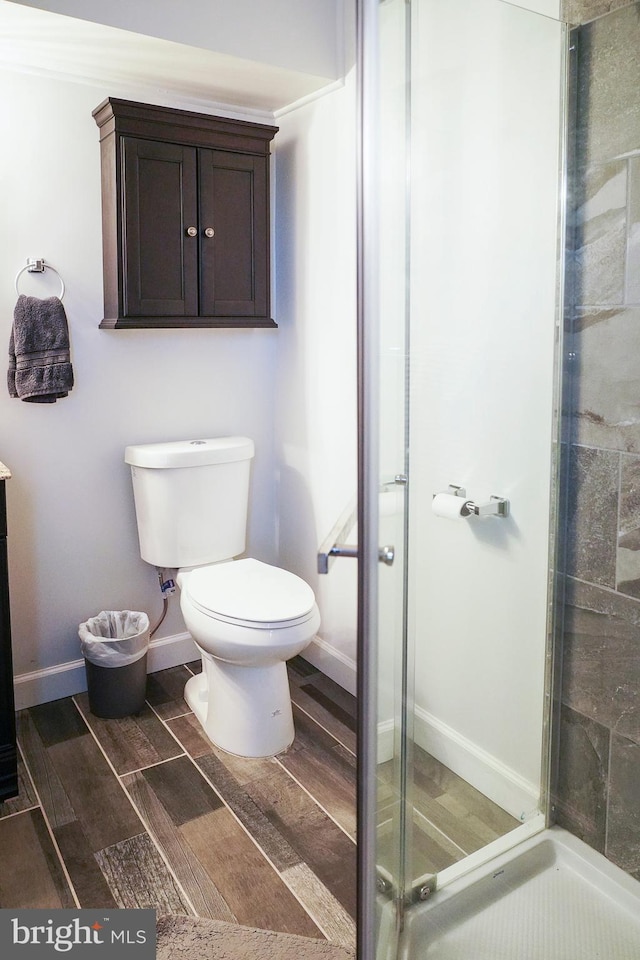 bathroom with a shower with door and toilet