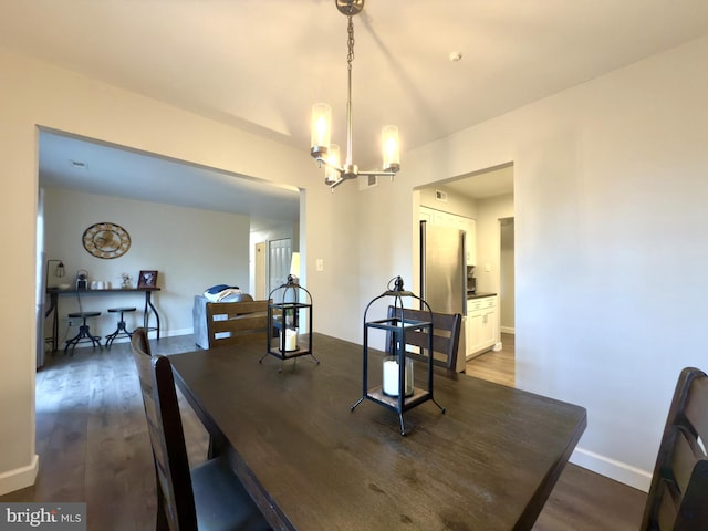 dining space with dark wood-type flooring and a chandelier