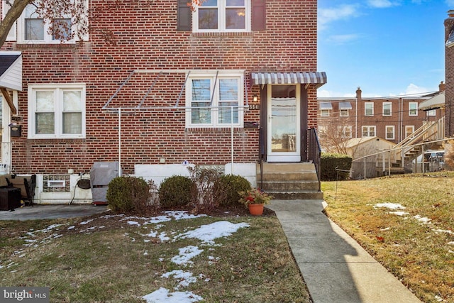 view of exterior entry featuring a lawn