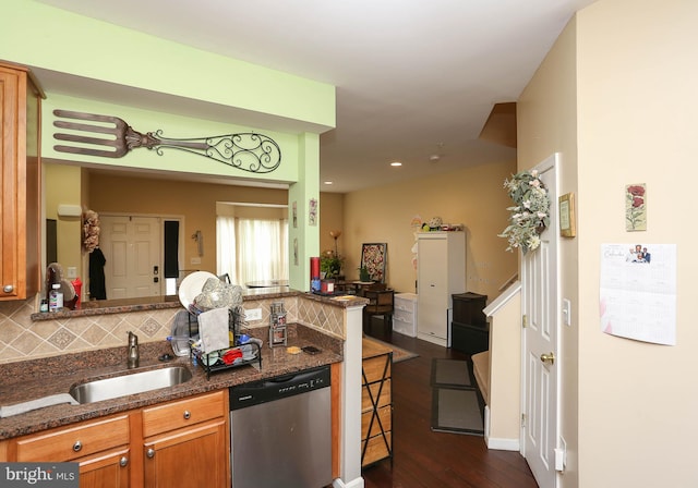 kitchen with sink, dark wood-type flooring, dark stone countertops, backsplash, and stainless steel dishwasher