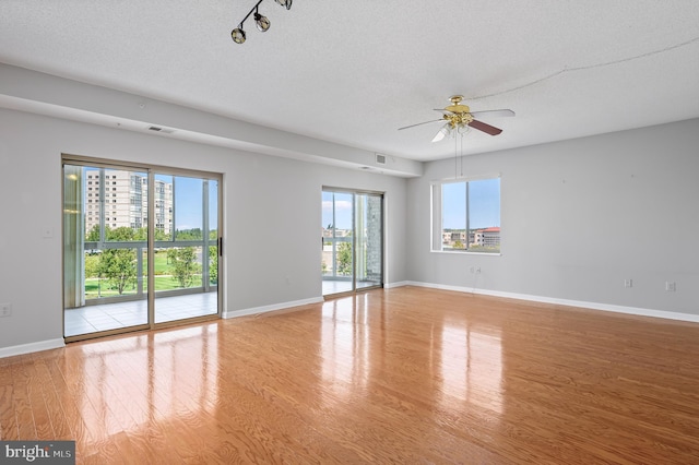 unfurnished room with ceiling fan, a textured ceiling, and light hardwood / wood-style floors