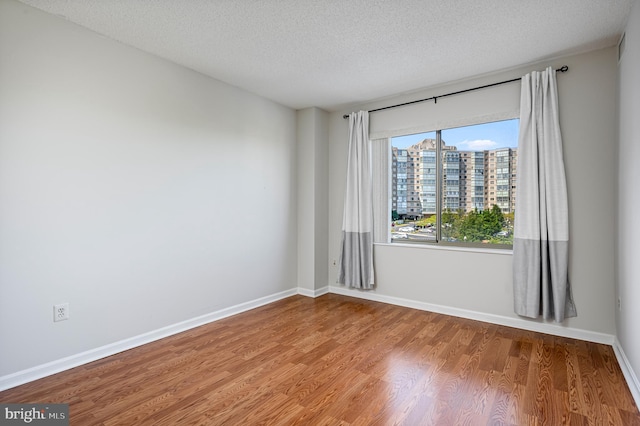 spare room with hardwood / wood-style floors and a textured ceiling