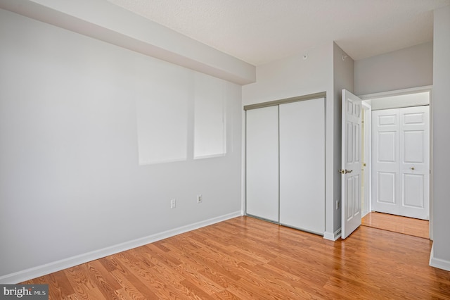 unfurnished bedroom featuring light wood-type flooring and a closet