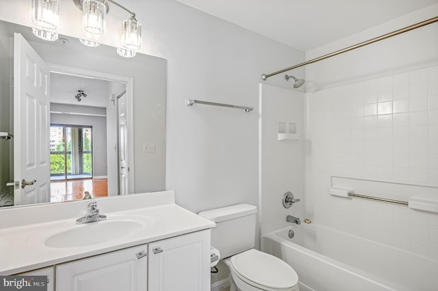 full bathroom with tiled shower / bath, vanity, and toilet