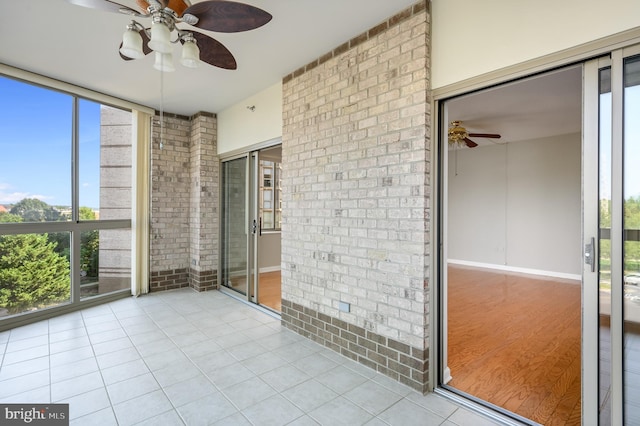 unfurnished sunroom with a wealth of natural light and ceiling fan