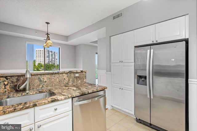 kitchen featuring sink, dark stone counters, white cabinets, and appliances with stainless steel finishes