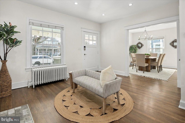 sitting room with a chandelier, dark hardwood / wood-style flooring, and radiator