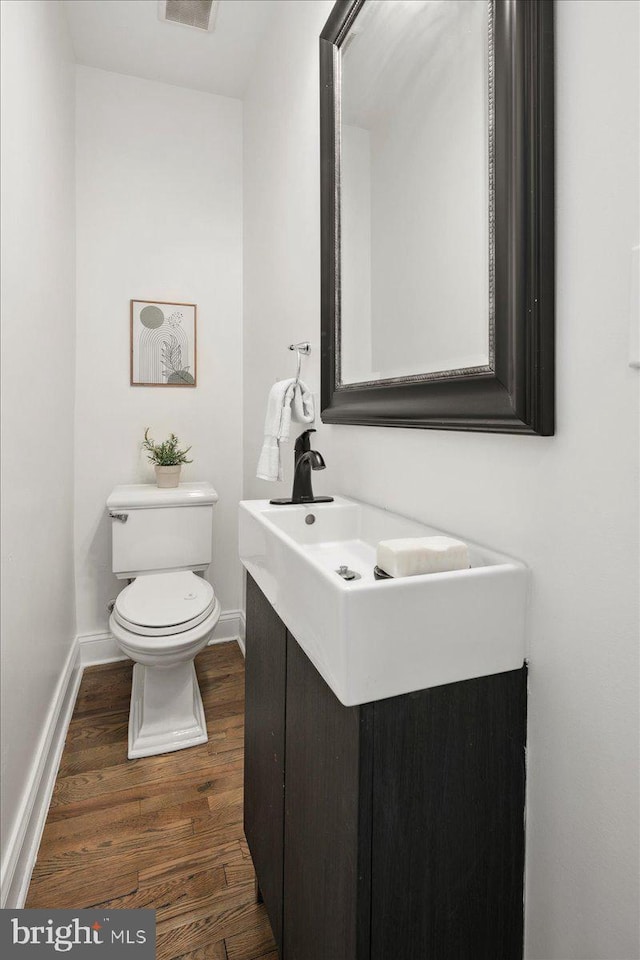 bathroom with vanity, hardwood / wood-style flooring, and toilet