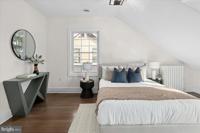 bedroom featuring dark wood-type flooring, radiator heating unit, and vaulted ceiling