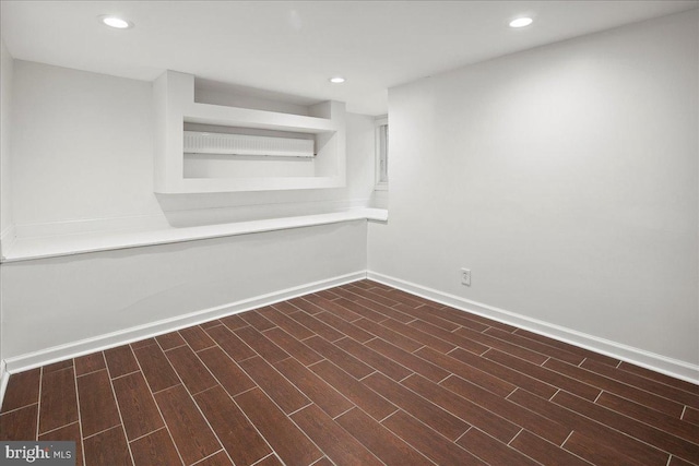 basement with dark hardwood / wood-style floors