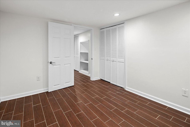 unfurnished bedroom featuring dark hardwood / wood-style flooring and a closet