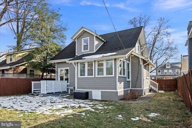 snow covered property featuring a wooden deck and a yard