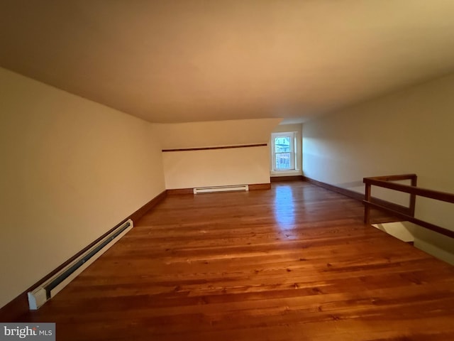 interior space featuring a baseboard heating unit and hardwood / wood-style floors