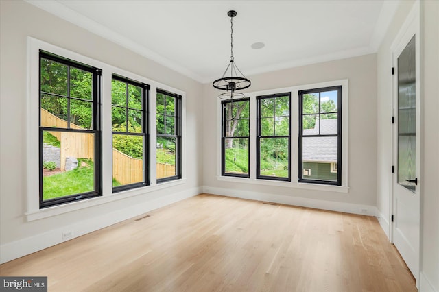 unfurnished dining area with light wood-style floors, baseboards, visible vents, and crown molding