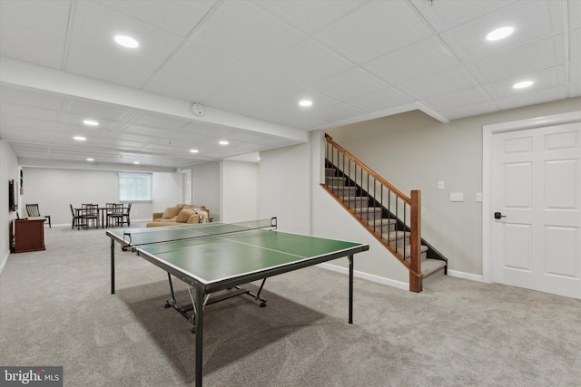 rec room featuring a paneled ceiling and light carpet