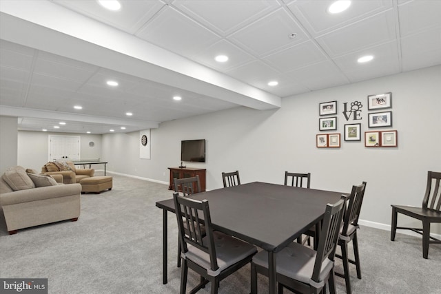 dining space featuring light carpet and a paneled ceiling