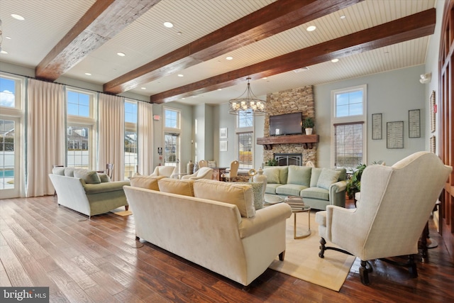 living room with a fireplace, a notable chandelier, wood-type flooring, and beamed ceiling