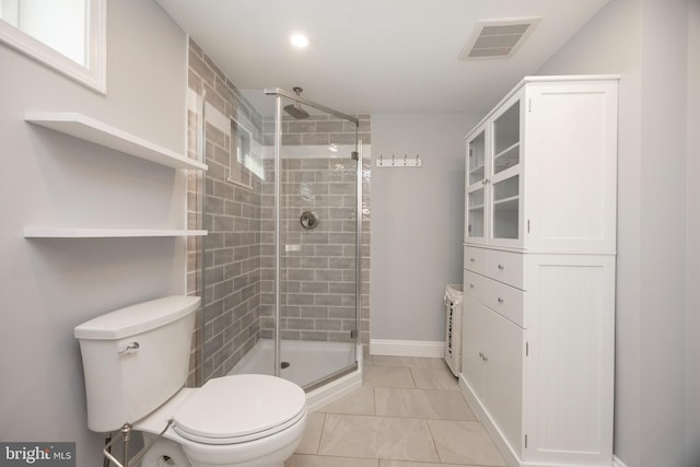 bathroom featuring a shower with shower door and toilet