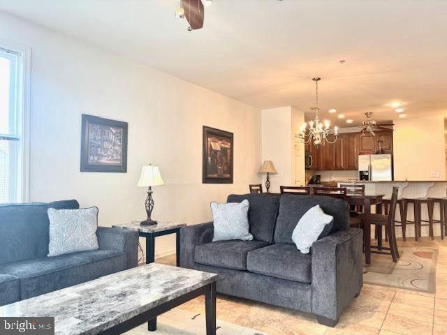 living room featuring ceiling fan with notable chandelier