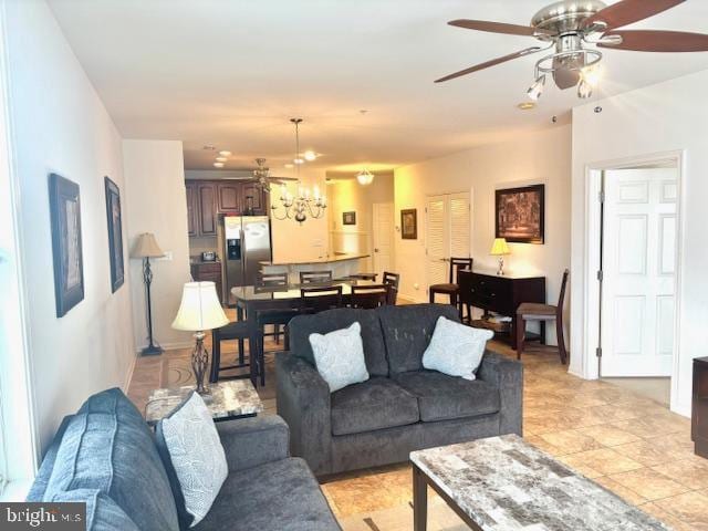 living room with ceiling fan with notable chandelier