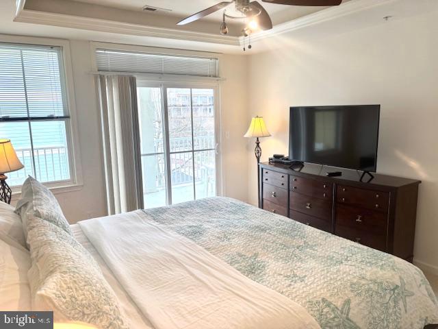 bedroom with a raised ceiling, ornamental molding, access to outside, and ceiling fan