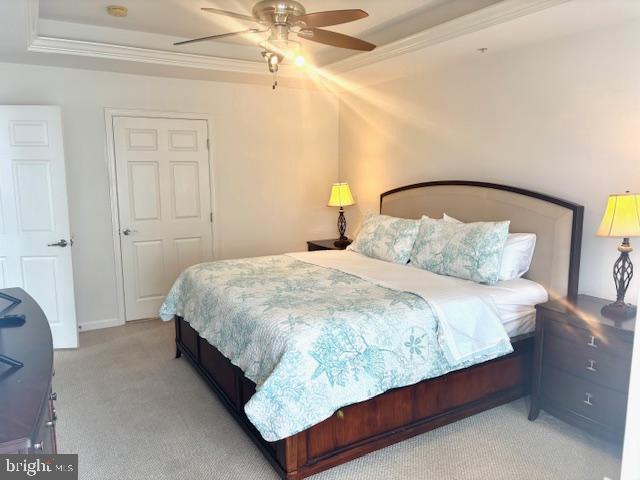 bedroom featuring light carpet, ornamental molding, and ceiling fan