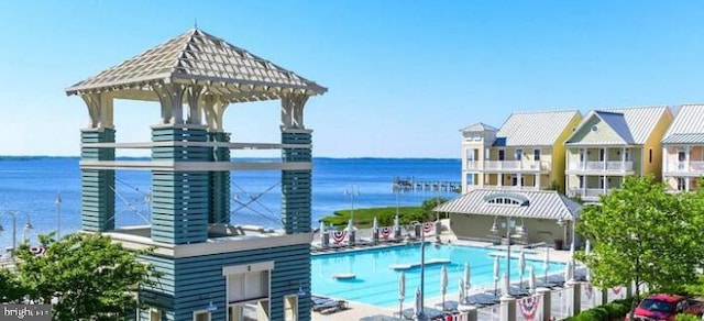 view of swimming pool with a water view and a patio area