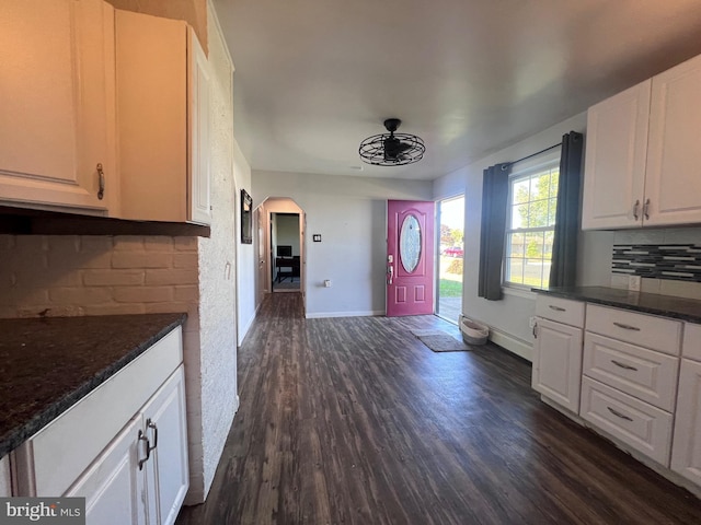 kitchen featuring dark stone countertops, dark hardwood / wood-style floors, decorative backsplash, and white cabinets