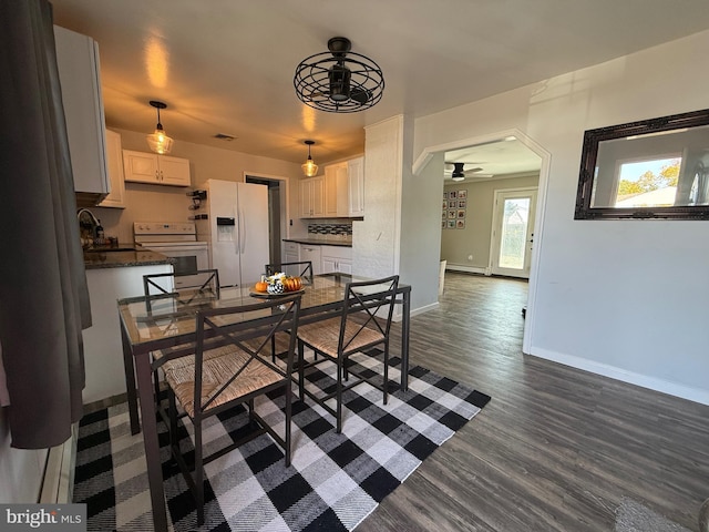 dining area with sink, dark wood-type flooring, and ceiling fan