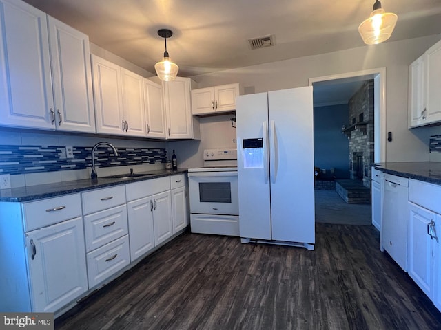 kitchen featuring pendant lighting, sink, white appliances, white cabinetry, and dark hardwood / wood-style flooring