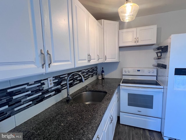 kitchen with white cabinetry, sink, backsplash, dark stone counters, and white appliances