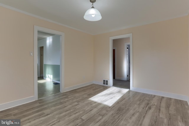 unfurnished room featuring ornamental molding and light hardwood / wood-style floors