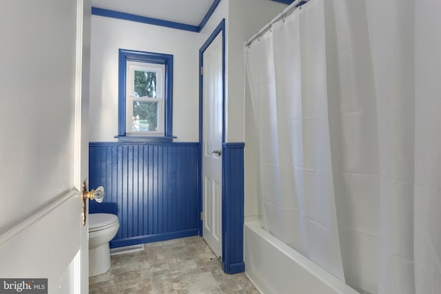 bathroom with shower / bathtub combination with curtain and toilet