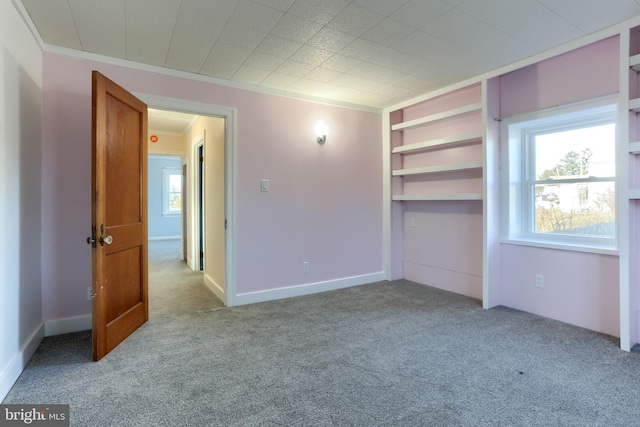 unfurnished bedroom with light colored carpet, ornamental molding, and a closet