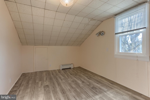 additional living space featuring vaulted ceiling and light wood-type flooring