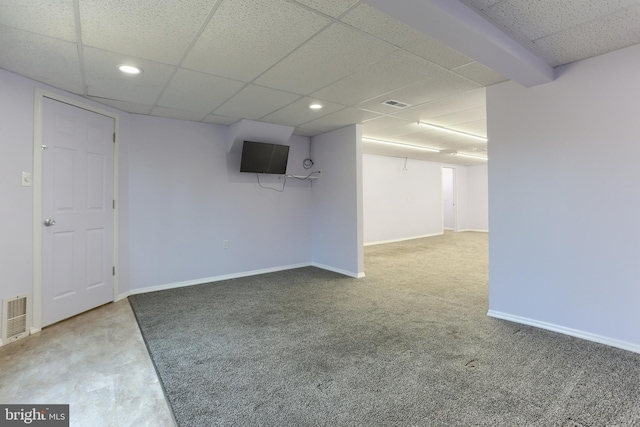 basement featuring a paneled ceiling and carpet