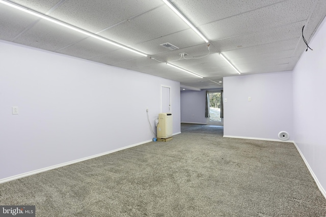 carpeted spare room with a drop ceiling