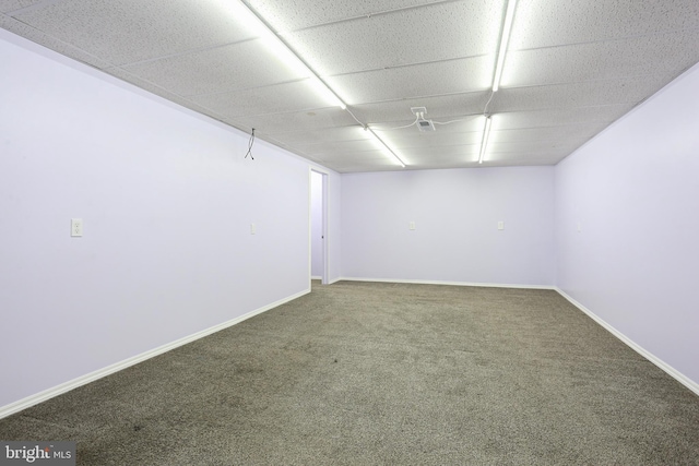 carpeted empty room featuring a paneled ceiling