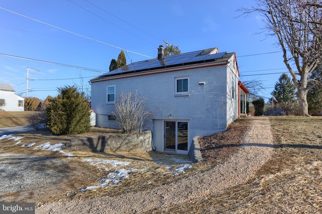 back of property featuring solar panels