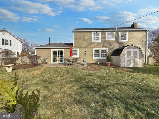 rear view of house featuring a lawn, a patio, and a storage unit